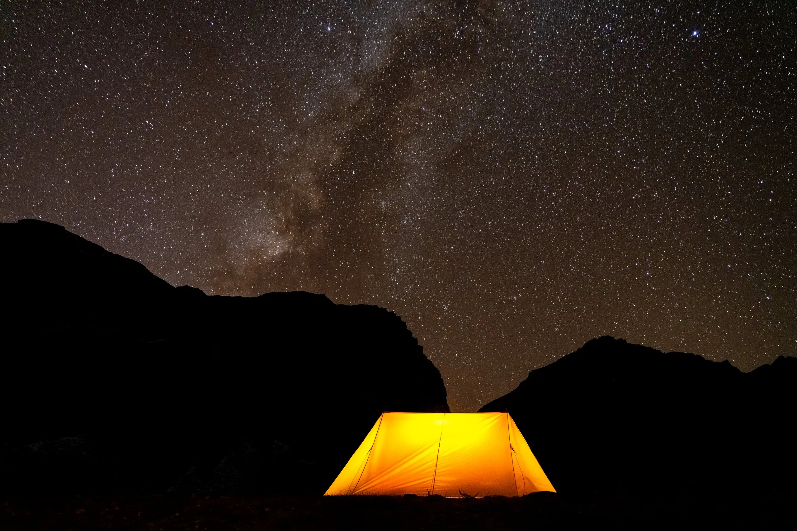 A glowing tent beneath the Milky Way on the Snowman Trek, Bhutan