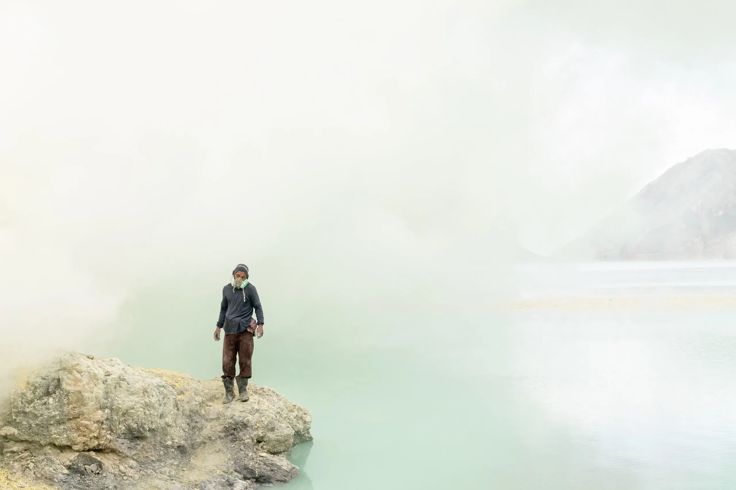 A lone figure at the acid crater lake of Kawah Ijen