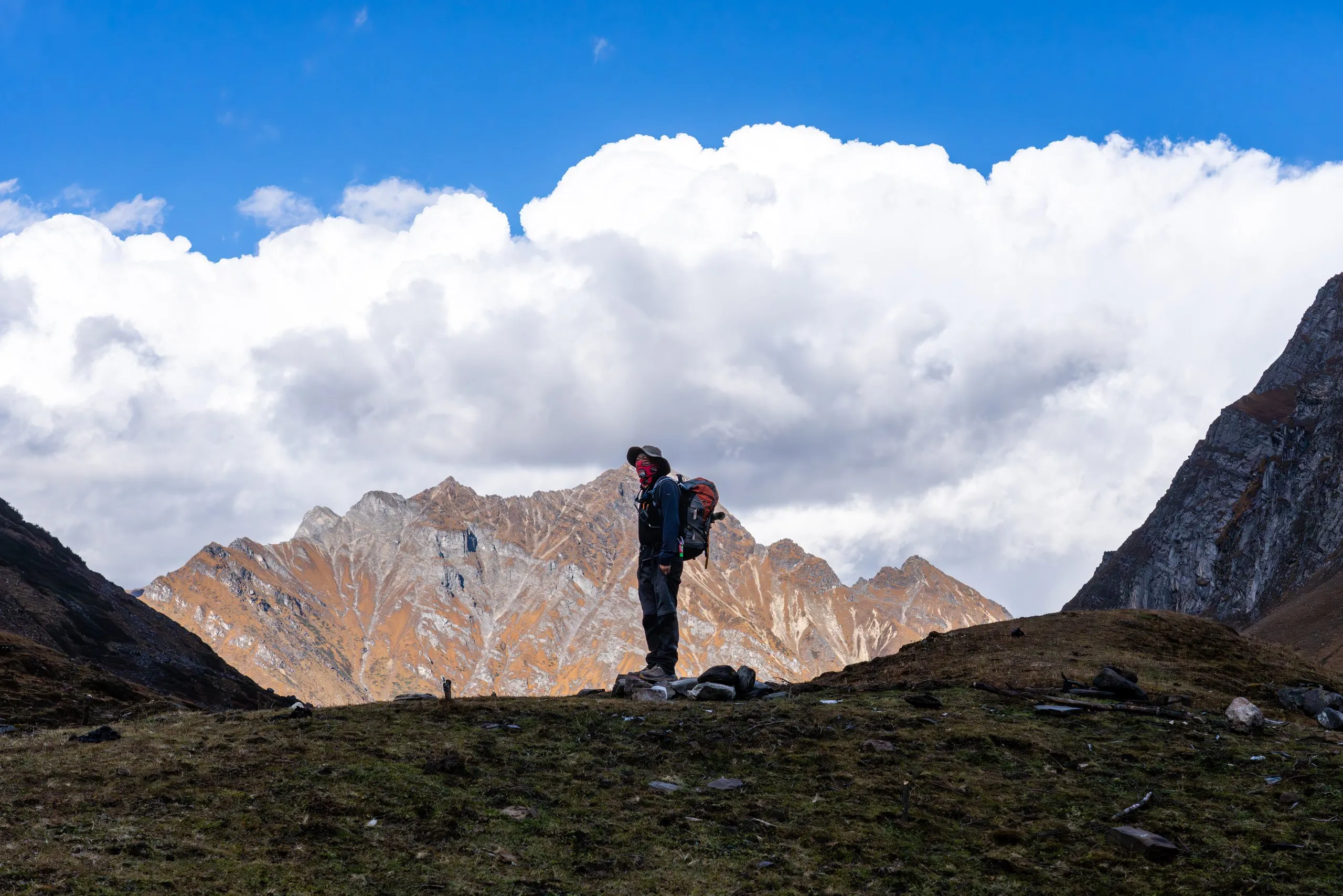A trekker overlooking a barren high valley